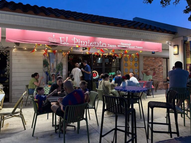 Outdoor terrace full of guests at El Pimiento Spanish restaurant in Miami Lakes during evening service